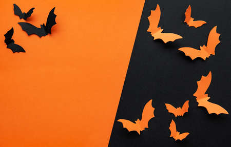 Black and orange paper bats flying over black and orangeの写真素材