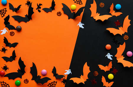 holidays  concept - halloween paper decorations and sweets with blank copy space over  orange and...