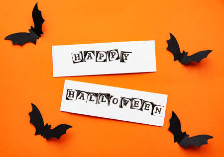 halloween  concept - black paper bats flying over orange background