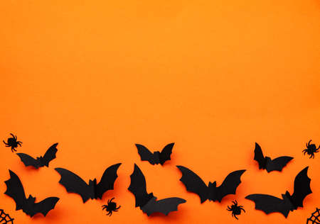 holidays  concept - halloween paper decorations and sweets with blank copy space over orange backgroundの写真素材