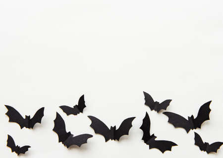 halloween  concept - black paper bats flying over grey background