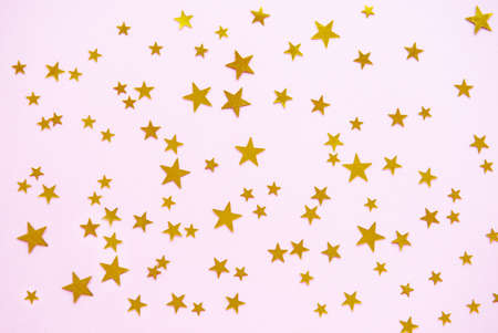 Pink pastel festive background with confetti. Christmas holiday background. Flat lay