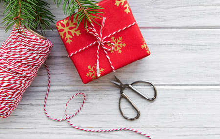 Christmas gift box on wooden background with fir branches. Xmas and Happy New Year composition. Flat...