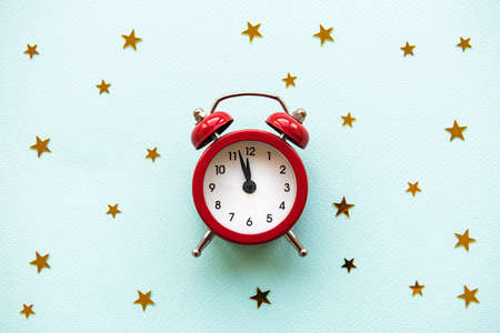 Flat lay Christmas composition with alarm clock and gold stars  on light blue background.の写真素材