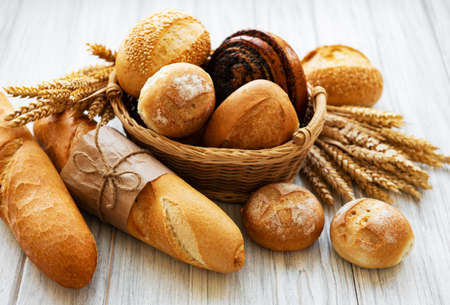 Assortment of baked bread on white wooden backgroundの写真素材