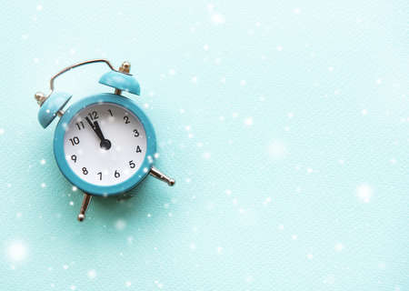 Flat lay Christmas composition with alarm clock and snow on light blue background.の写真素材