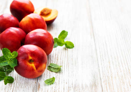 Fresh nectarines on a white wooden tableの写真素材