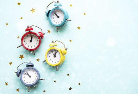 Flat lay composition with color alarm clocks  and golden stars on light blue background.の写真素材