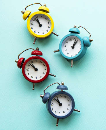 Flat lay Christmas composition with color alarm clocks  on light blue background.