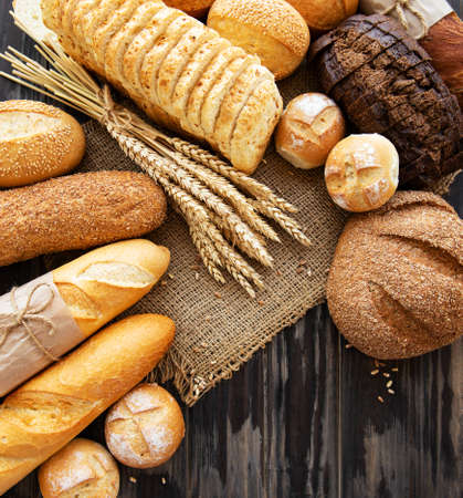 Assortment of baked bread on old wooden  backgroundの写真素材