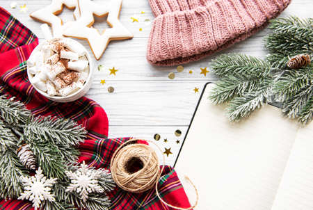 Christmas Tree Pine Branches and Hot Chocolate  with gingerbread cookies, open notebook on a wooden table. Holiday background with copyspace. Top viewの写真素材