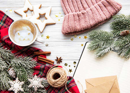 Christmas Tree Pine Branches and cup of coffee with gingerbread cookies, open notebook on a wooden table. Holiday background with copyspace. Top viewの写真素材