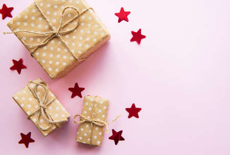 Christmas gift boxes with fir on pink pastel background. Copy space. Top view, flat lay