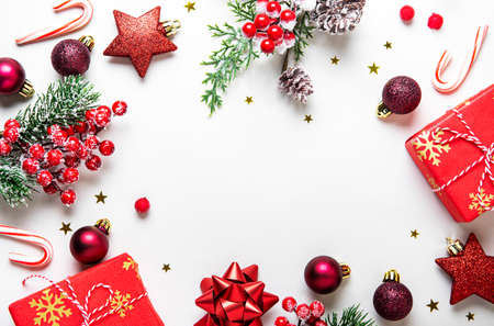 Christmas composition. Gifts, fir tree branches, red decorations on white background. Christmas, winter, new year concept. Flat lay, top view, copy spaceの写真素材