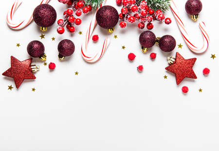 Christmas holiday background. Border made of red decorations on white background. Christmas, winter,...