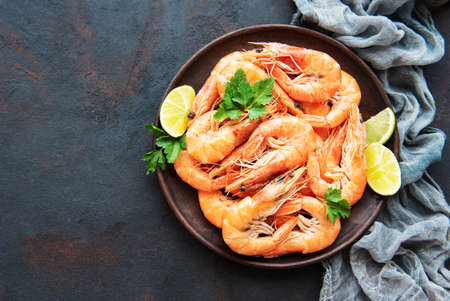 Shrimps served with lemons and spices on a black backgroundの写真素材