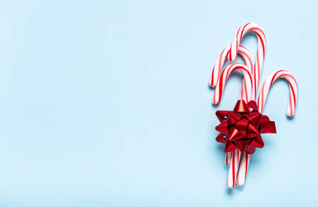 Candy canes with red bow on pastel blue  background. Flat lay.の写真素材