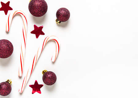 Christmas holiday background. Border made of red decorations on white background. Christmas, winter, new year concept. Flat lay, top view, copy spaceの写真素材