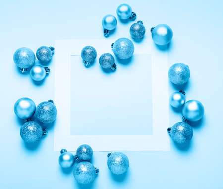 Christmas balls and  paper  frame  top view. Fashion background. Flat lay. Party mockup or invitation toned classic blue colorの写真素材