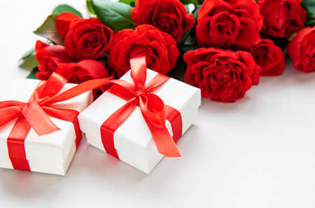 Frame made of red roses and gift boxes  s on white background. Flat lay, top view, copy space.の写真素材