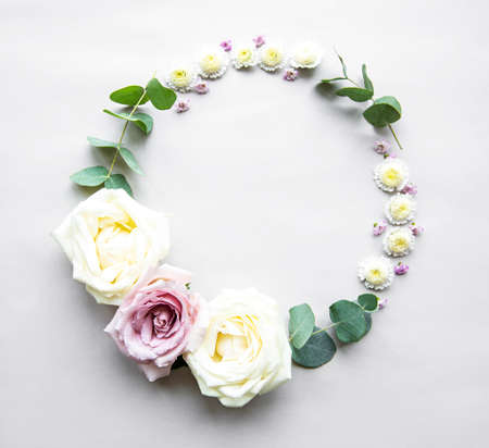 Decorative circle frame with pink and white roses and leaves on white background. Flat layの写真素材