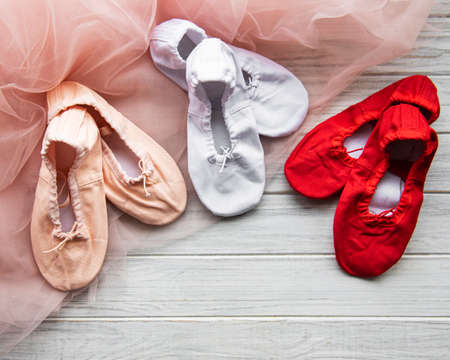 child's ballet slippers  on pink tulle backgroundの写真素材