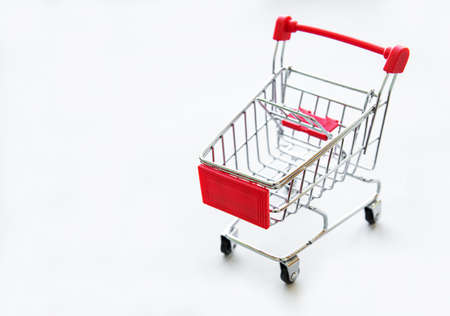 Small supermarket grocery push cart for shopping  on white background. の写真素材