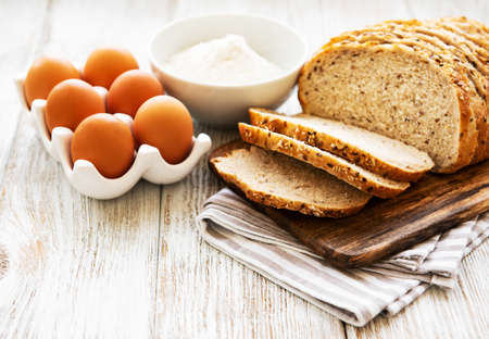 Bread, eggs and flour on a old wooden tableの写真素材