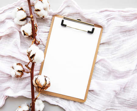 Stylized arranged office accessories clipboard,  cotton flowers. Women's fashion accessories  on...