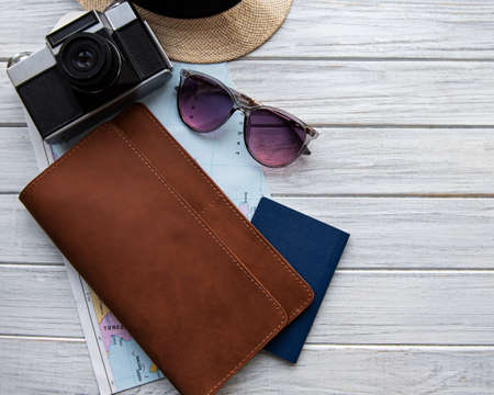 Brown leather travel organizer on white wooden table.  Flat lay, top view. Travel concept.