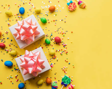 Happy birthday or party background.  Flat Lay wtih gifts, confetti and candy on yellow background. Top View.  Copy space.の写真素材