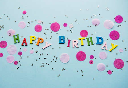 Text Happy Birthday by wooden  letters with candles and confetti  on blue backgroundの写真素材