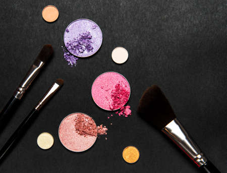 Assorted colors metallic blusher or eyeshadow  on black background. Flat lay, top viewの写真素材