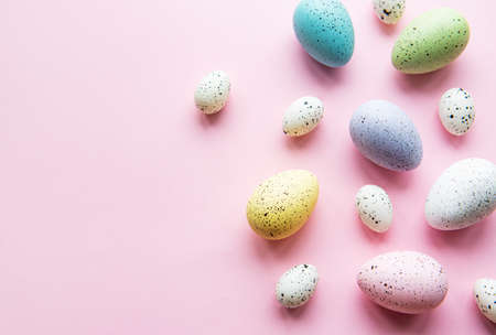 Easter holiday background. Colorful Easter eggs on a pastel pink background. Flat lay, top view.の写真素材