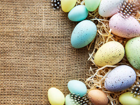 Easter eggs on a sackcloth and straw . Happy Easter  multicolored  easter eggs. Background with easter eggs. Flat lay, top view.の写真素材