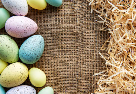Easter eggs on a sackcloth and straw . Happy Easter  multicolored  easter eggs. Background with easter eggs. Flat lay, top view. の写真素材
