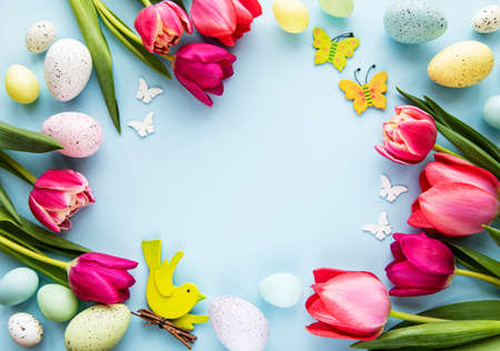 Spring tulip flowers, Easter eggs and gift box  on pastel blue background. Greeting for Easter.  Top view, flat lay.の写真素材
