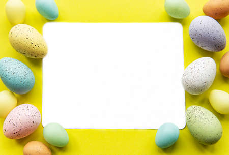 Easter greeting card. Colorful easter eggs on yellow background and place for text. Top view, flat...