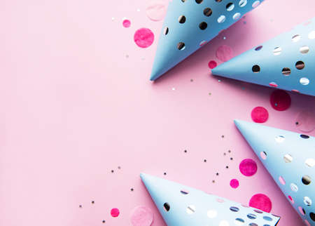 Happy birthday or party background.  Flat Lay with birthday hats and confetti  on pink background. Top View.  Copy space.の写真素材