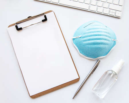 Clipboard, disposable medical mask, personal protective equipment, bottle of antiseptic. Coronavirus concept.の写真素材
