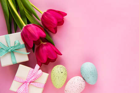Spring tulip flowers, Easter eggs and gift box  on pastel pink