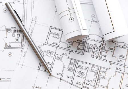 Architect workplace top view. Architectural project, blueprints, blueprint rolls on table. Construction background. Engineering tools. Copy spaceの写真素材