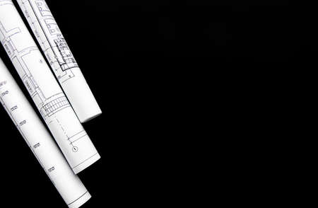 Architect workplace top view. Architectural project, blueprints, blueprint rolls on table. Construction background. Engineering tools. Copy spaceの写真素材