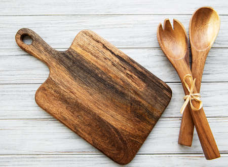 Old vintage kitchen utensils. Wooden spoons,  cutting board over white wooden table. Top viewの写真素材