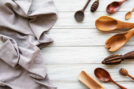 Old vintage kitchen utensils. Wooden spoons, napkin over white wooden table. Top viewの写真素材