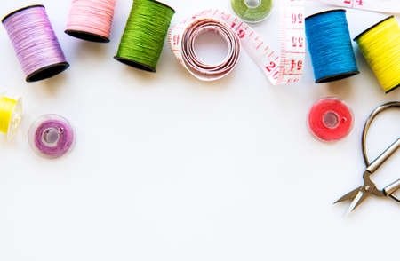 Sewing accessories and fabric on a white background. Sewing threads, needles, pins, fabric, buttons...