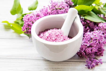 Spa sea salt in mortar and lilac flowers. の写真素材
