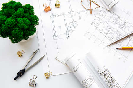 Architect workplace top view. Architectural project, blueprints, blueprint rolls on table....
