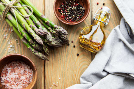 Bundle of fresh green asparagus on a rustic wooden table , top viewの写真素材