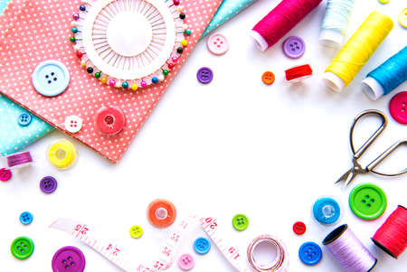 Sewing accessories and fabric on a white background. Sewing threads, needles, pins, fabric, buttons...